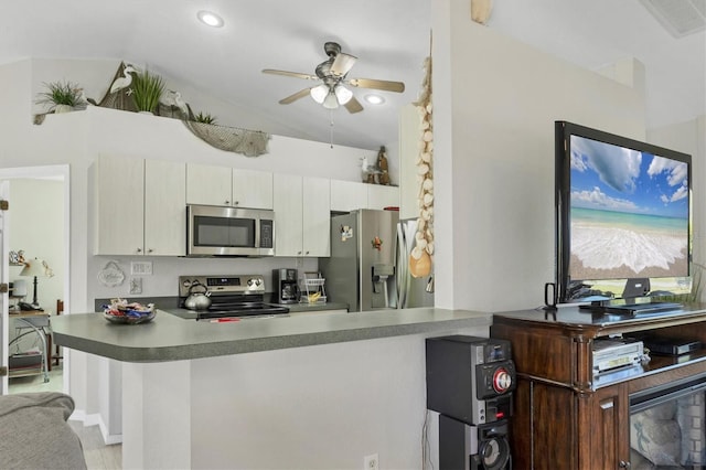 kitchen with kitchen peninsula, appliances with stainless steel finishes, vaulted ceiling, and ceiling fan