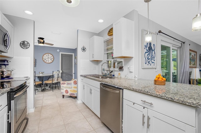 kitchen featuring sink, white cabinets, hanging light fixtures, light stone counters, and stainless steel appliances