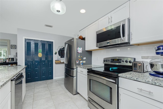 kitchen with backsplash, light stone countertops, white cabinets, and appliances with stainless steel finishes