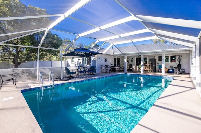 view of swimming pool featuring a patio area, ceiling fan, and glass enclosure