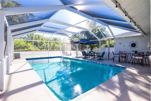 view of swimming pool featuring a patio area and glass enclosure