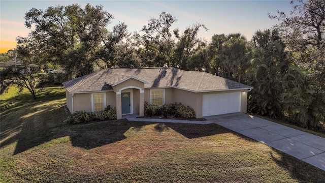 single story home with a lawn and a garage