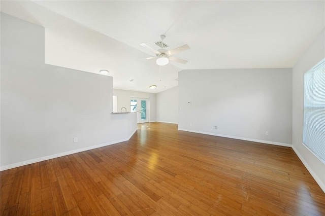 unfurnished living room with hardwood / wood-style flooring, ceiling fan, and a healthy amount of sunlight