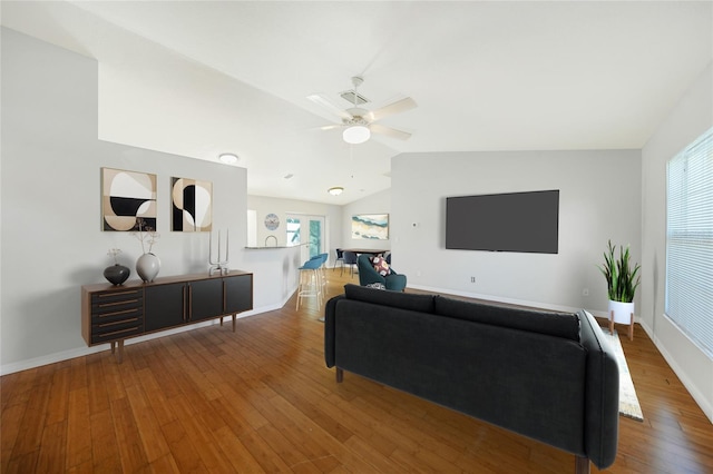 living room with hardwood / wood-style flooring, vaulted ceiling, and ceiling fan