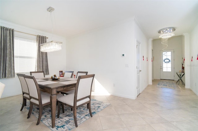 dining area with light tile patterned floors, crown molding, and a chandelier