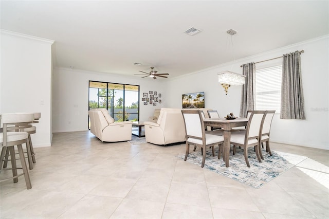 tiled dining area with ceiling fan and ornamental molding