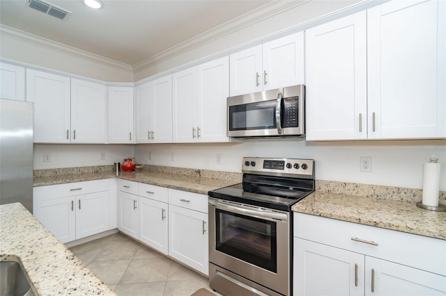 kitchen featuring crown molding, white cabinets, light stone counters, and appliances with stainless steel finishes