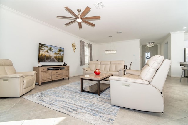 tiled living room with ceiling fan with notable chandelier and crown molding