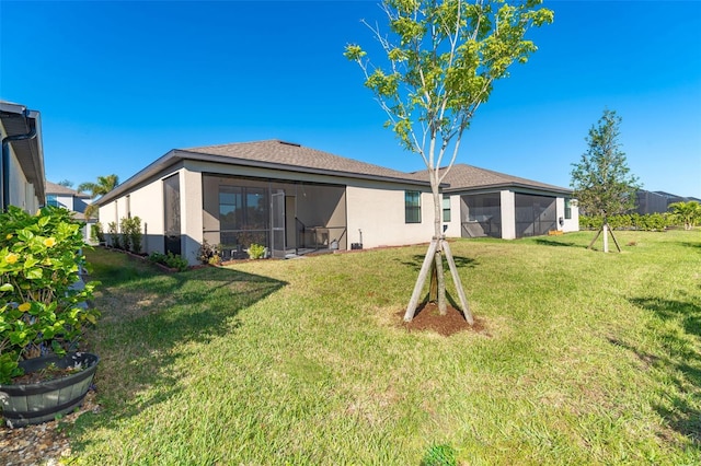 rear view of property with a sunroom and a yard