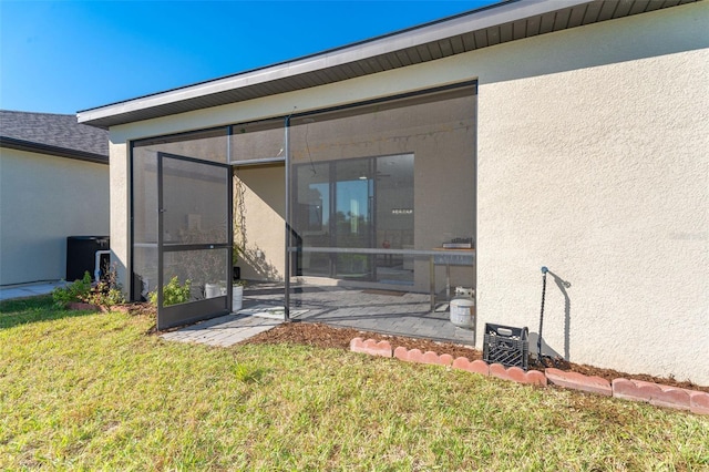 back of house with a sunroom, a yard, and a patio