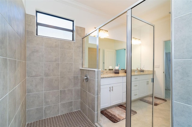 bathroom featuring tile patterned floors, crown molding, vanity, and tiled shower