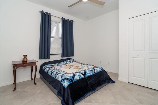 tiled bedroom with ceiling fan and a closet