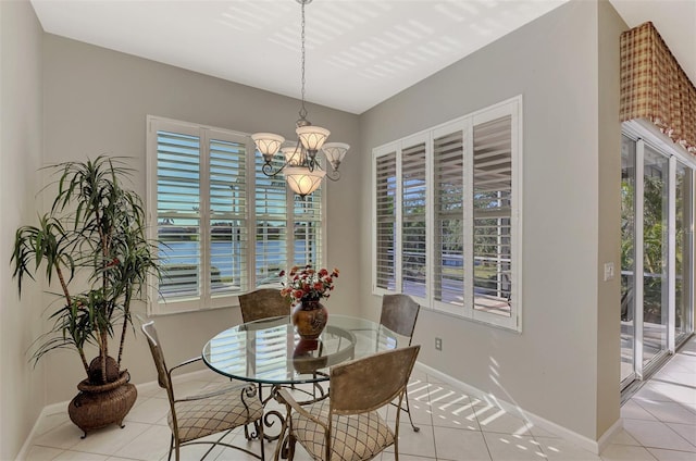 dining space with an inviting chandelier, a wealth of natural light, and light tile patterned flooring