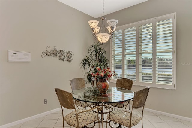 dining room featuring light tile patterned flooring, a healthy amount of sunlight, and an inviting chandelier