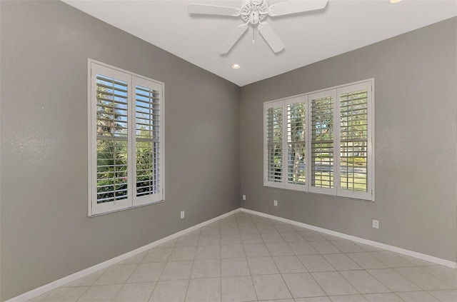 tiled spare room featuring a wealth of natural light and ceiling fan