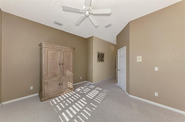 unfurnished bedroom featuring ceiling fan, light carpet, and vaulted ceiling