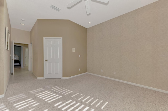 carpeted spare room featuring ceiling fan and vaulted ceiling