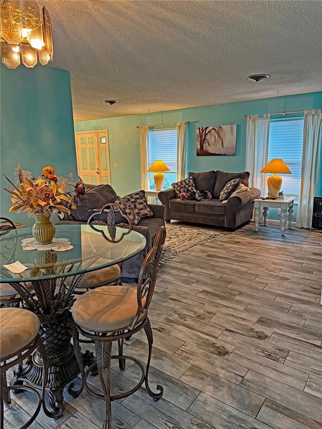 dining space with hardwood / wood-style floors and a textured ceiling