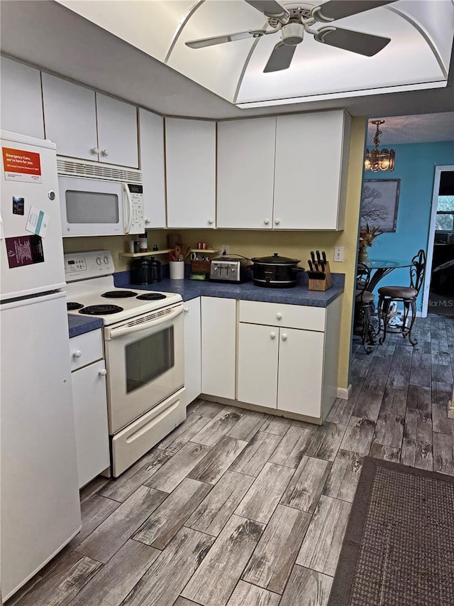 kitchen featuring white appliances, hardwood / wood-style flooring, and white cabinetry