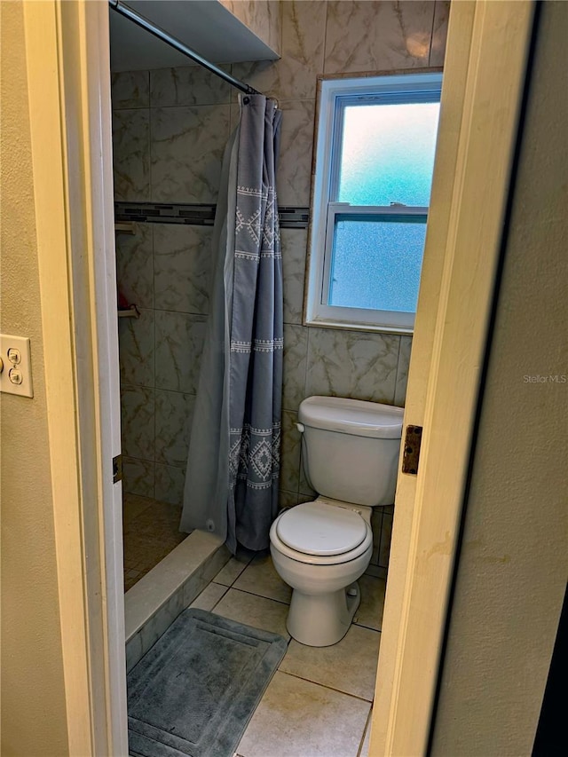 bathroom featuring tile patterned floors, toilet, and walk in shower