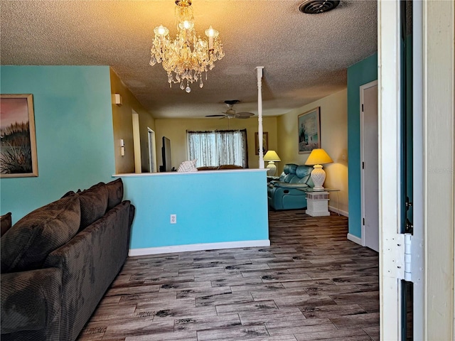 living room with a textured ceiling, ceiling fan with notable chandelier, and hardwood / wood-style flooring