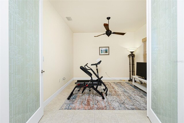 workout room with light tile patterned floors and ceiling fan