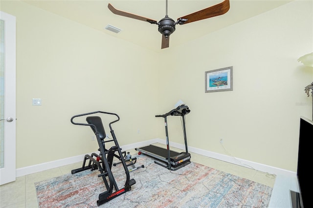 exercise room with ceiling fan and light tile patterned floors