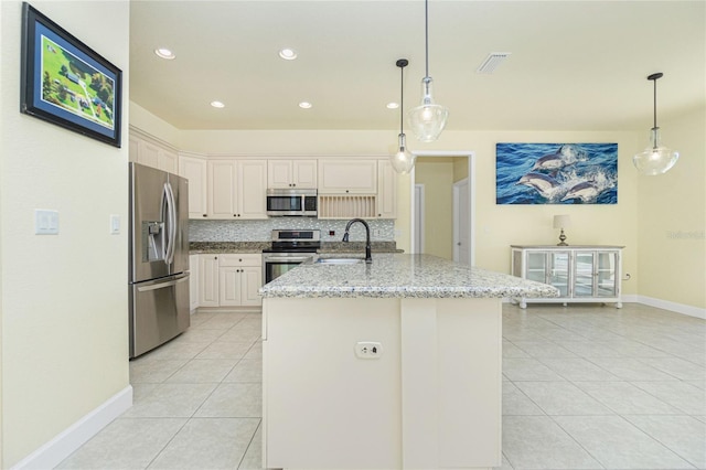 kitchen with light stone countertops, sink, stainless steel appliances, backsplash, and pendant lighting