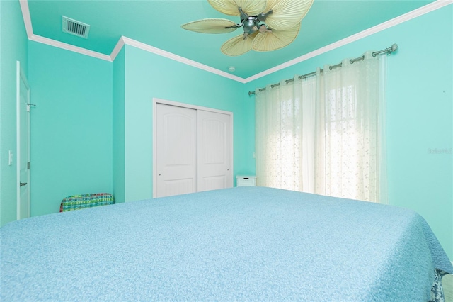 bedroom featuring ceiling fan, ornamental molding, and a closet