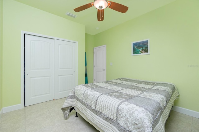 bedroom with ceiling fan, a closet, and light tile patterned floors