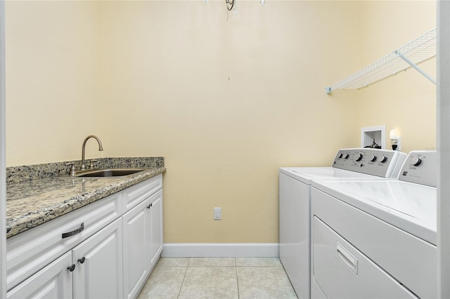 laundry area featuring washer and clothes dryer, light tile patterned flooring, cabinets, and sink