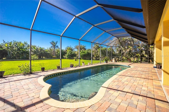 view of swimming pool featuring glass enclosure, a yard, and a patio