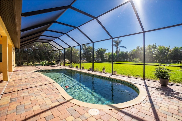 view of pool featuring glass enclosure, a patio area, and a yard