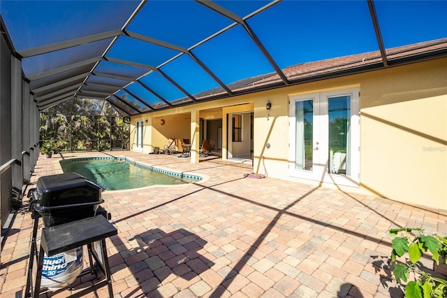 view of swimming pool with a lanai, a patio area, and french doors