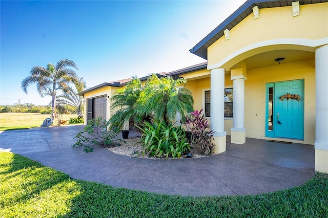 doorway to property featuring a porch and a garage