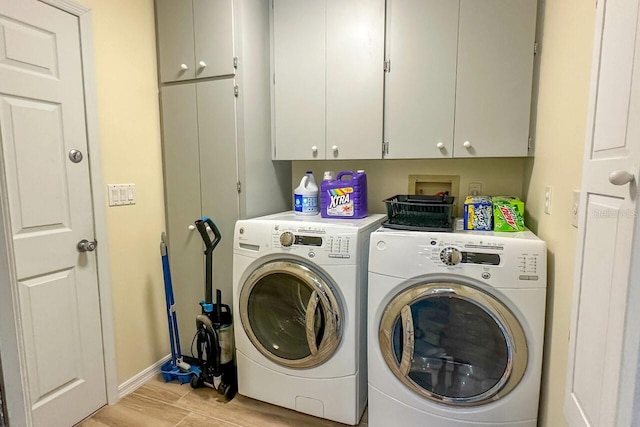 laundry room with cabinets, separate washer and dryer, and light hardwood / wood-style flooring