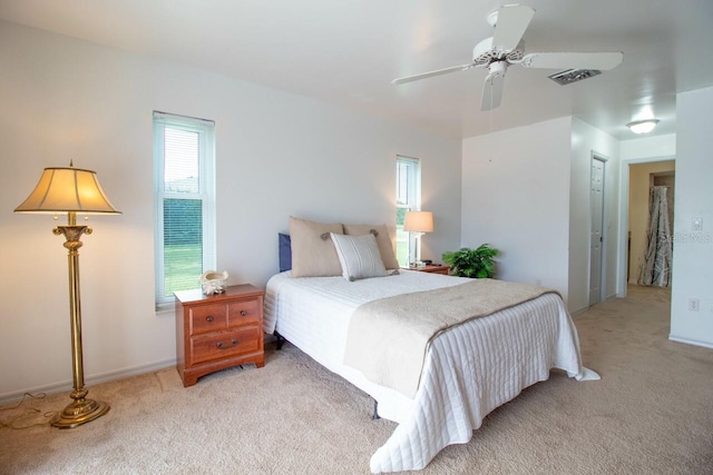 bedroom featuring a closet, light colored carpet, and ceiling fan