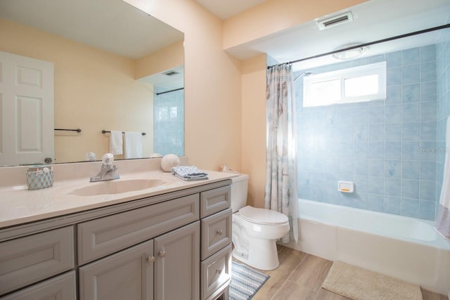 full bathroom featuring hardwood / wood-style floors, shower / bath combo, toilet, and vanity