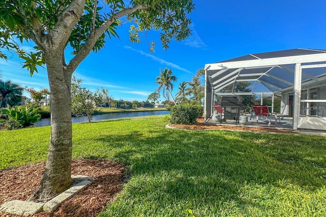 view of yard featuring a lanai, a patio area, and a water view