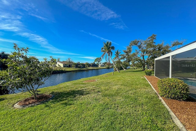 view of yard featuring a water view and glass enclosure