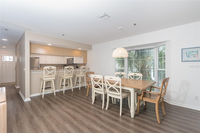 dining space with dark hardwood / wood-style flooring