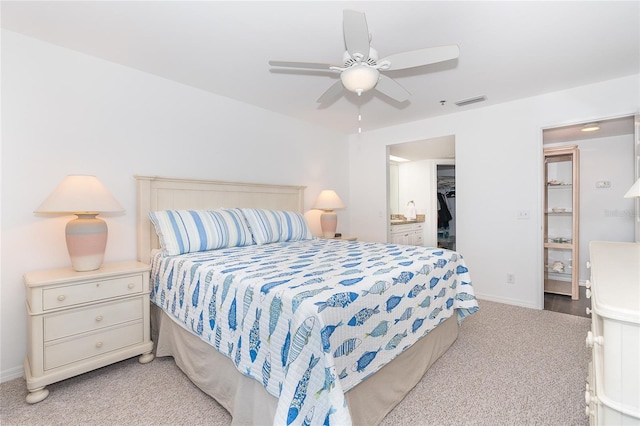 carpeted bedroom featuring ceiling fan, a closet, and a spacious closet