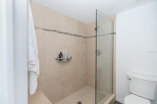 bathroom featuring a tile shower and toilet