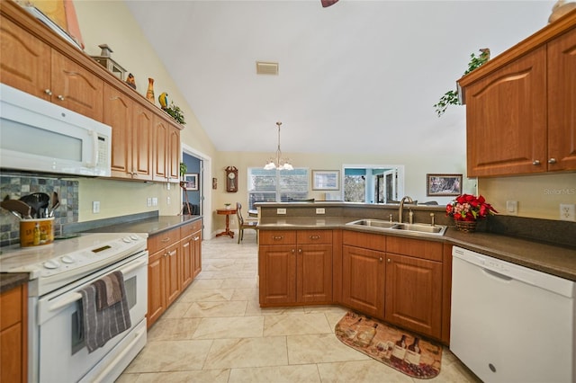 kitchen featuring white appliances, an inviting chandelier, sink, hanging light fixtures, and vaulted ceiling