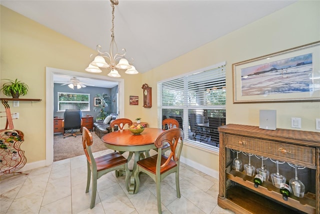 dining space featuring ceiling fan with notable chandelier and vaulted ceiling