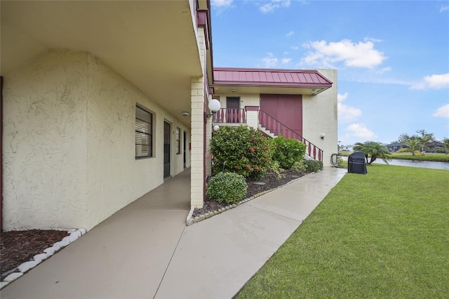 view of side of property with a lawn and a water view