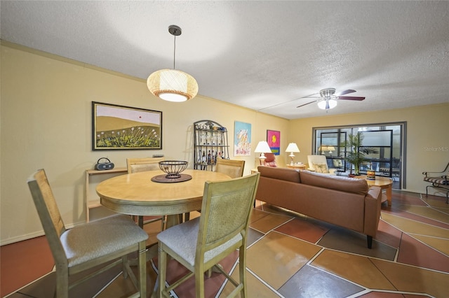 tiled dining room featuring ceiling fan and a textured ceiling