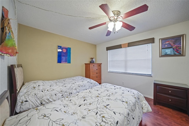 bedroom featuring hardwood / wood-style floors, ceiling fan, and a textured ceiling