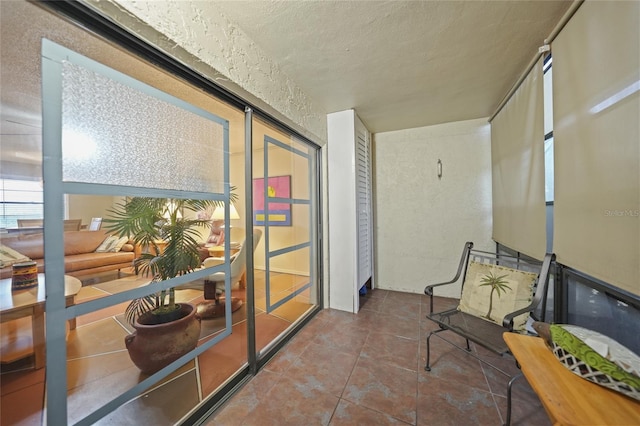 hall featuring tile patterned flooring and a textured ceiling