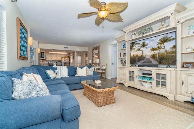 living room with ceiling fan and wood-type flooring